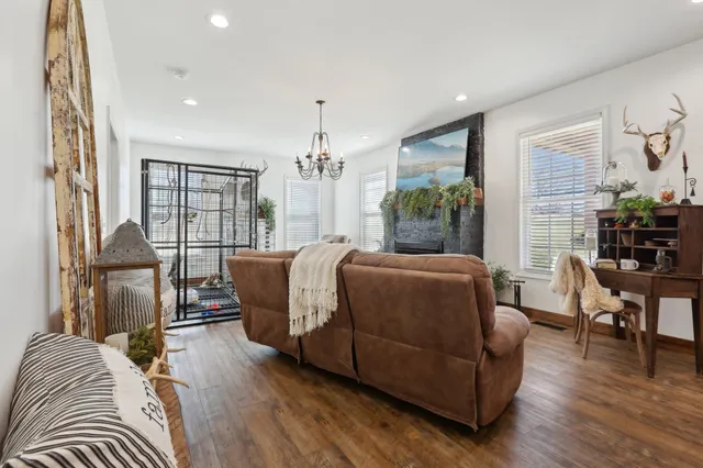 a living room with furniture a large window and wooden floor