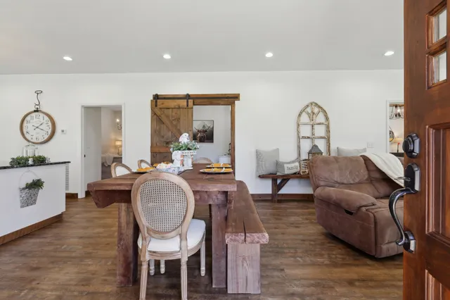 a living room with furniture a mirror and wooden floor