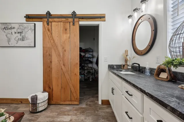 a bathroom with a granite countertop sink and a mirror