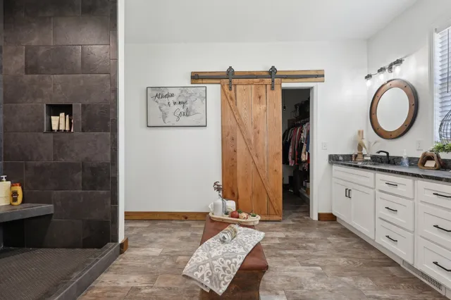 a spacious bathroom with a granite countertop sink and a mirror