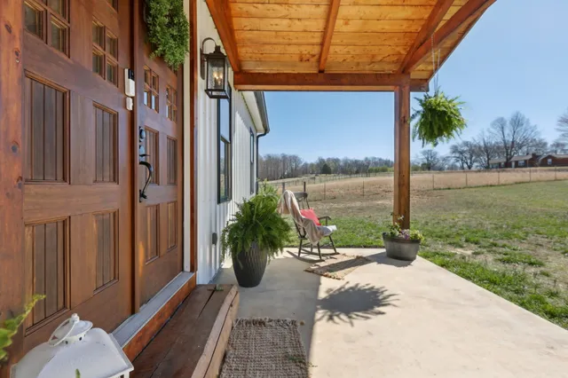 a view of a house with a yard and potted plants