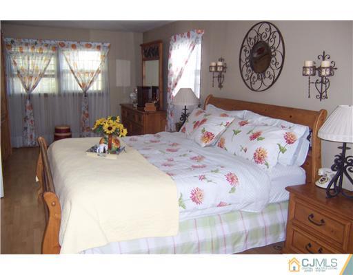69 Morningside Road Colonia, NJ 07067 - Photo 12 of 25 a bed with a bed and a painting on the wall