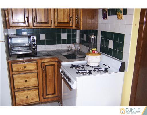 69 Morningside Road Colonia, NJ 07067 - Photo 18 of 25 a kitchen with stainless steel appliances granite countertop a stove and a refrigerator