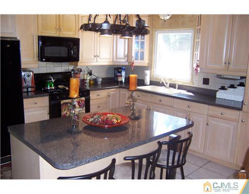69 Morningside Road Colonia, NJ 07067 - Photo 3 of 25 a kitchen with a table chairs and microwave