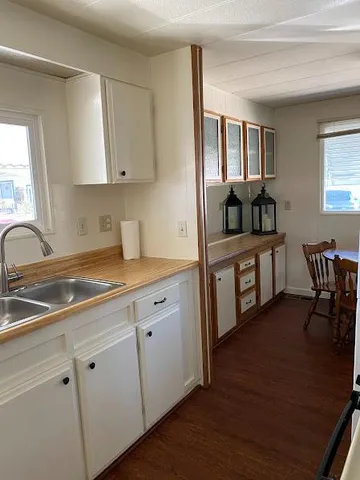 a kitchen with a sink cabinets and wooden floor