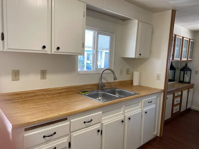 a kitchen with granite countertop white cabinets and white appliances