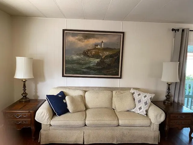 a living room with a couch and a lamp on a dresser