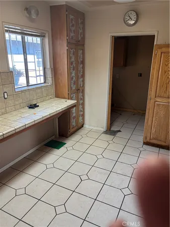 a large white kitchen with a sink and washing machine