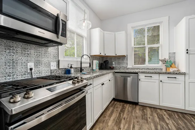 a kitchen with appliances a sink and cabinets