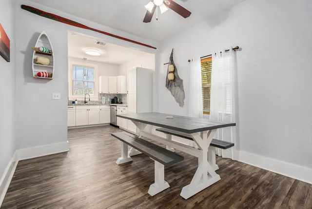 a living room with stainless steel appliances furniture a rug and a window