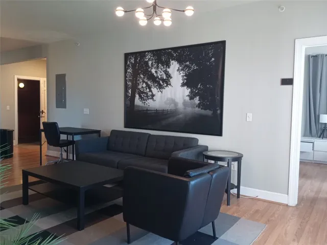 a living room with furniture and a painting on the wall