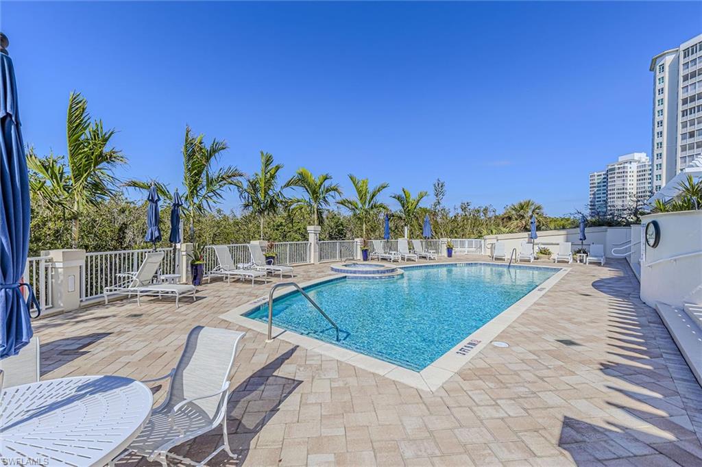 295 Grande Way, Unit PH2 Naples, FL 34110 - Photo 38 of 45 a view of a swimming pool with a lounge chair and palm trees