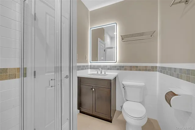 a bathroom with a granite countertop toilet and a sink