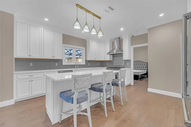 a kitchen with kitchen island granite countertop wooden cabinets and refrigerator