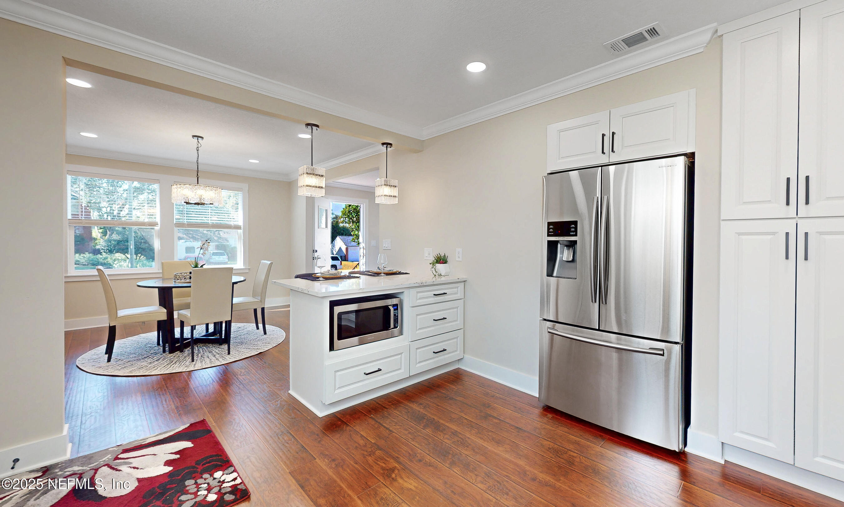 1153 Monticello Road Jacksonville, FL 32207 - Photo 13 of 37 a kitchen with a refrigerator a stove a sink and a dining table with wooden floor