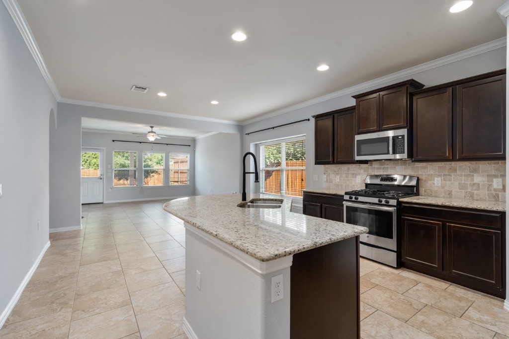 5704 Arbor Hill Lane Austin, TX 78747 - Photo 1 of 32 a kitchen with stainless steel appliances granite countertop a stove top oven a sink dishwasher a dining table and chairs with wooden floor