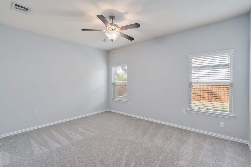 5704 Arbor Hill Lane Austin, TX 78747 - Photo 12 of 32 an empty room with windows and fan