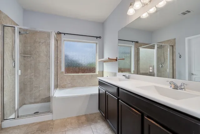 a bathroom with a bath tub sink mirror and a shower
