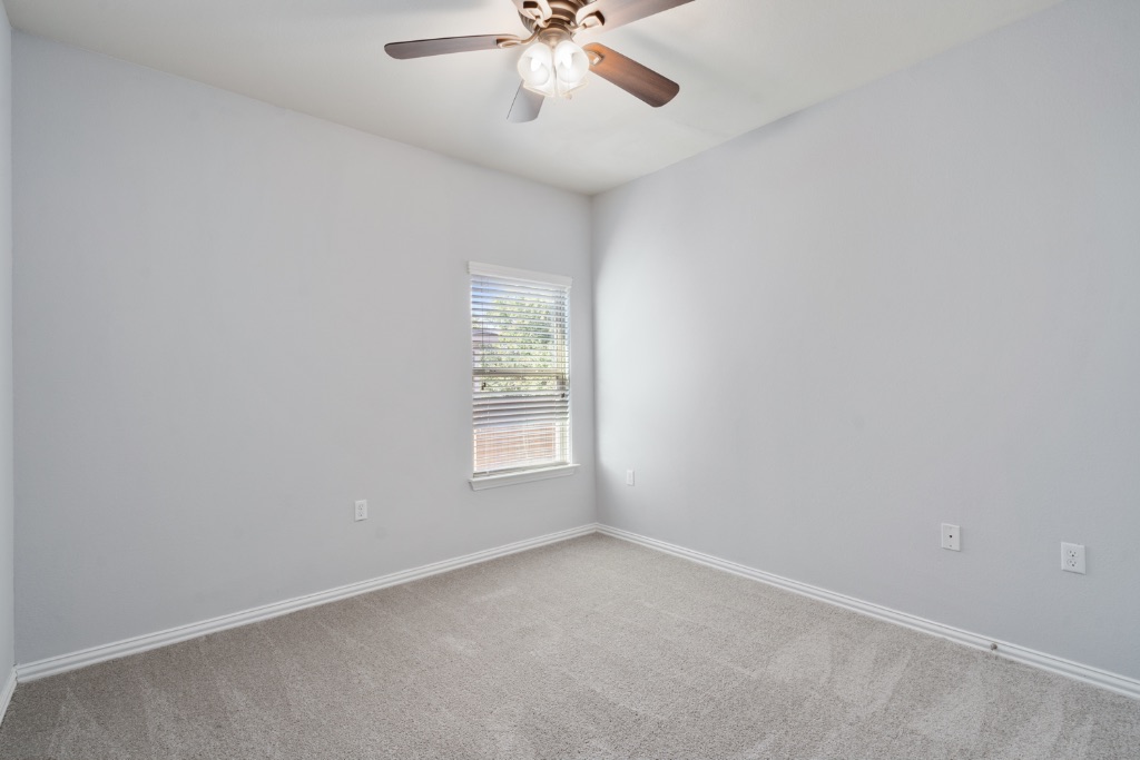 5704 Arbor Hill Lane Austin, TX 78747 - Photo 16 of 32 an empty room with windows and chandelier fan