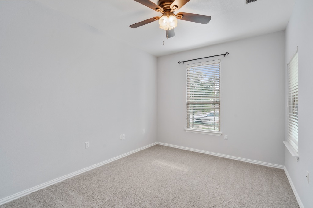 5704 Arbor Hill Lane Austin, TX 78747 - Photo 21 of 32 an empty room with a window and a fan