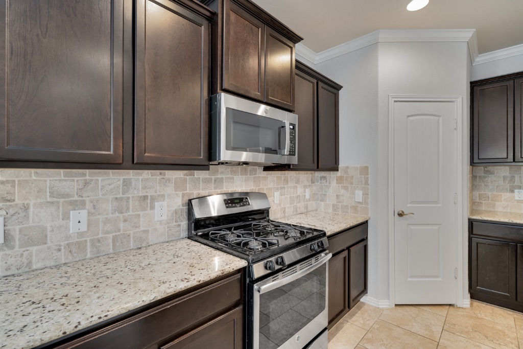 5704 Arbor Hill Lane Austin, TX 78747 - Photo 7 of 32 a kitchen with granite countertop cabinets stainless steel appliances and wooden floor