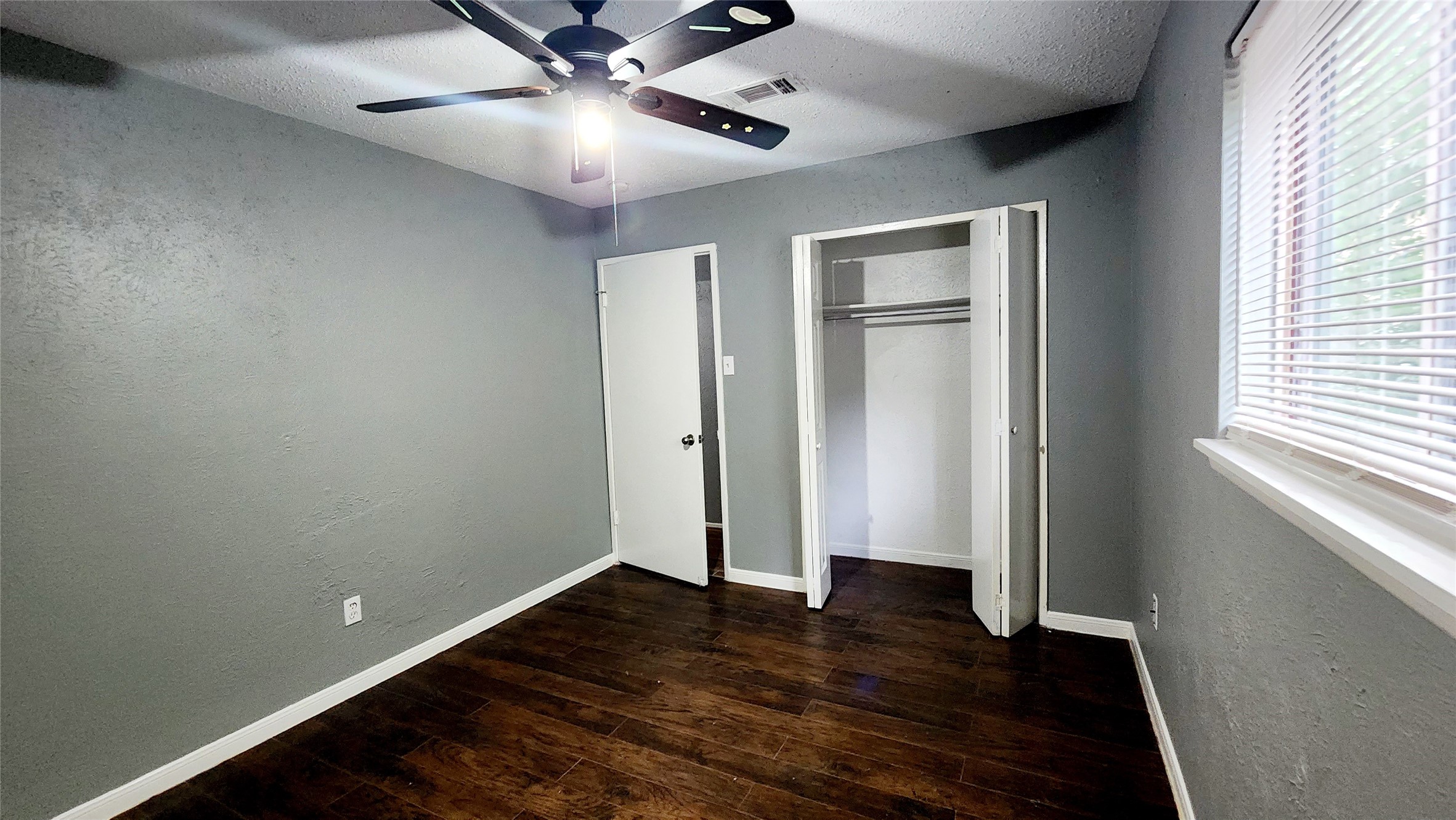 24119 Anchor Ranch Drive Hockley, TX 77447 - Photo 5 of 11 an empty room with wooden floor chandelier fan and windows