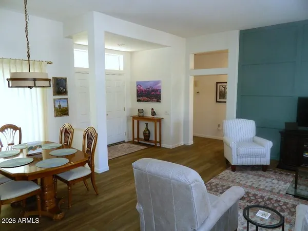 a living room with furniture and a dining table with wooden floor
