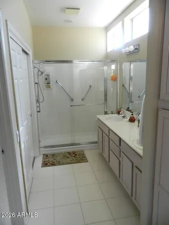 a bathroom with a double vanity sink toilet and shower