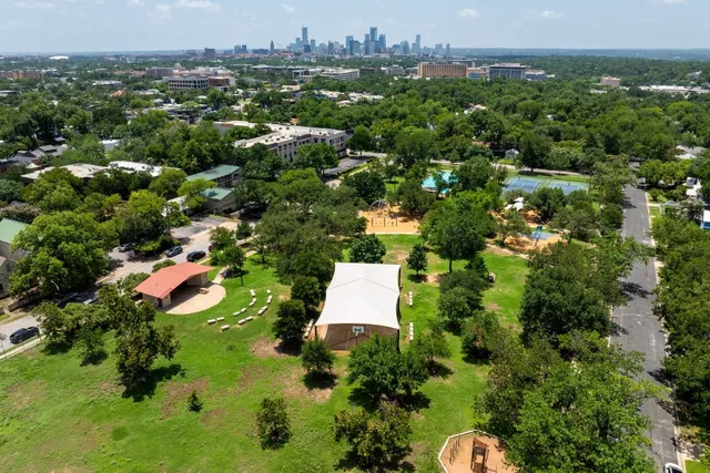 an aerial view of a residential houses with a yard and lake view