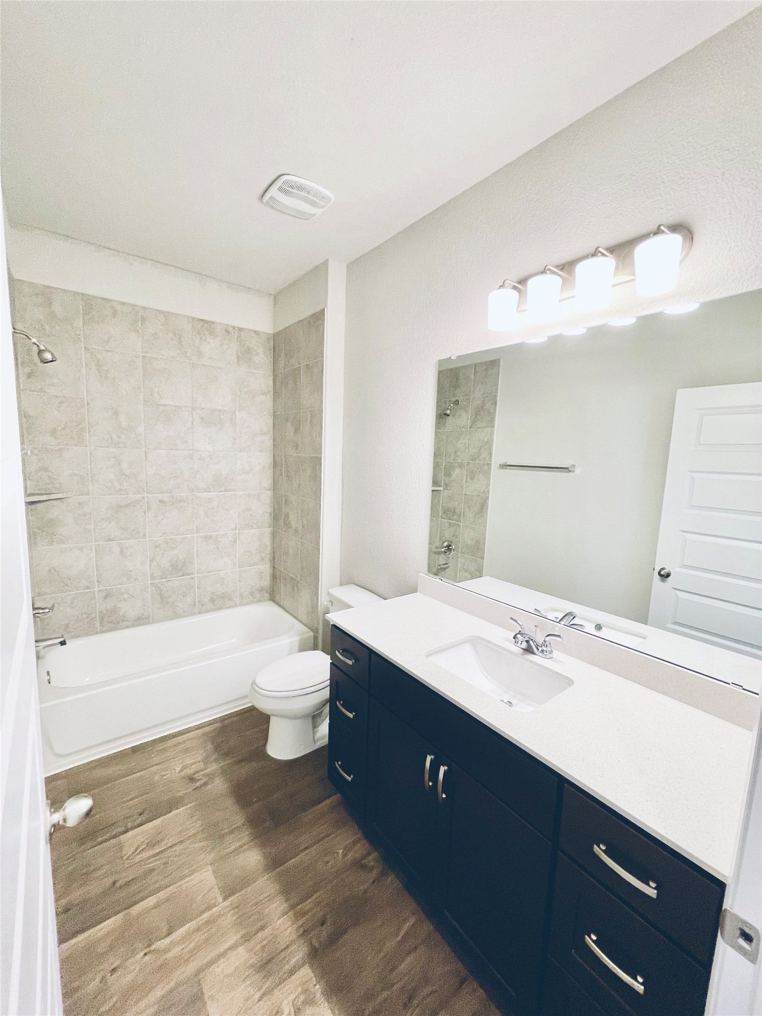 117 Huckleberry Lane Elgin, TX 78621 - Photo 17 of 34 Full bathroom with vanity, wood finished floors, toilet, and shower / bath combination
