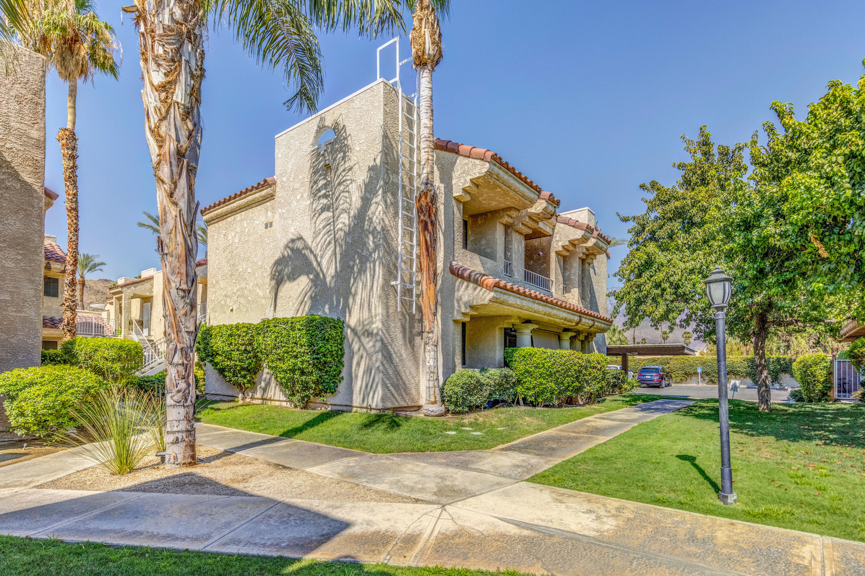 2700 Lawrence Crossley Road, Unit 9 Palm Springs, CA 92264 - Photo 1 of 27 a view of a big building with a yard and plants