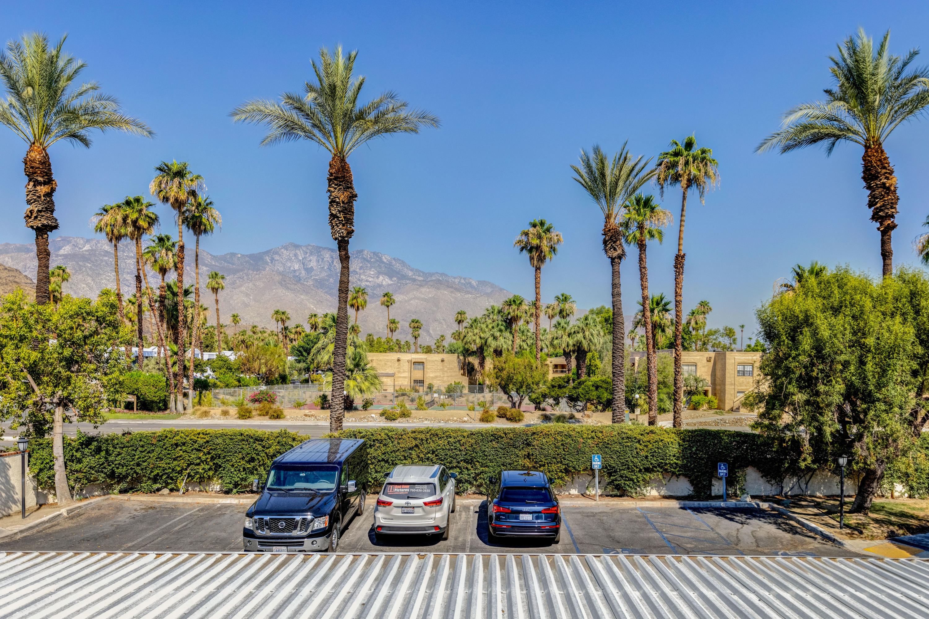 2700 Lawrence Crossley Road, Unit 9 Palm Springs, CA 92264 - Photo 21 of 27 a view of a patio with table and chairs potted plants with wooden floor and fence
