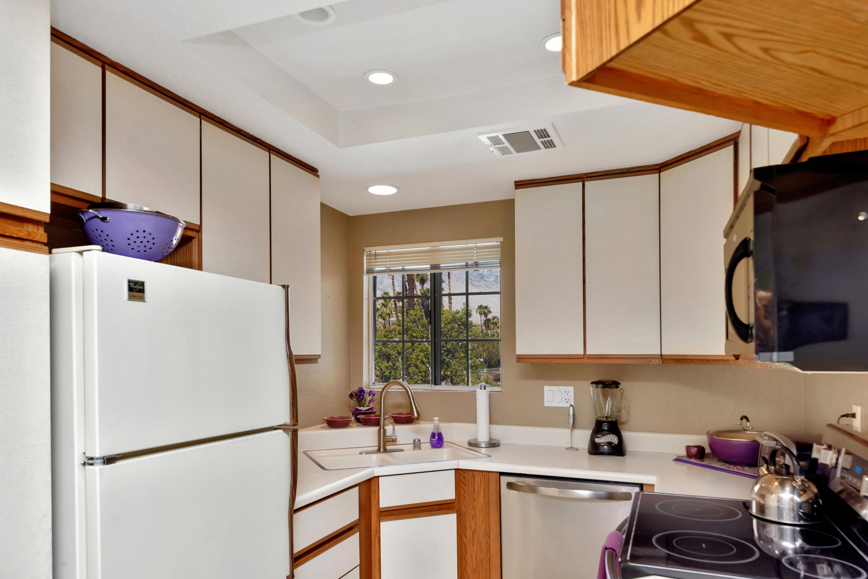 2700 Lawrence Crossley Road, Unit 9 Palm Springs, CA 92264 - Photo 8 of 27 a kitchen with stainless steel appliances a refrigerator sink and white cabinets