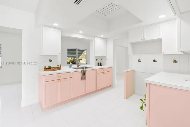a kitchen with white cabinets and sink
