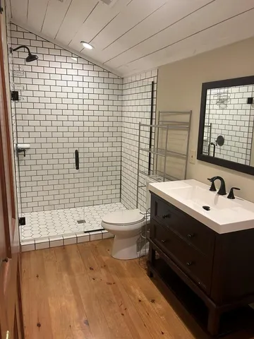 a bathroom with a sink a toilet and shower