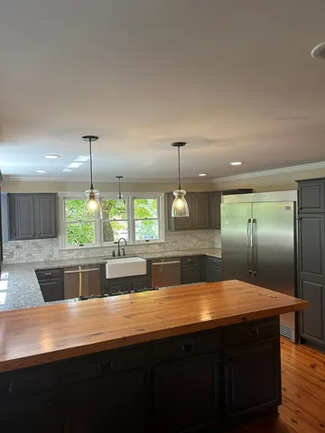 a large kitchen with kitchen island a sink stainless steel appliances and cabinets