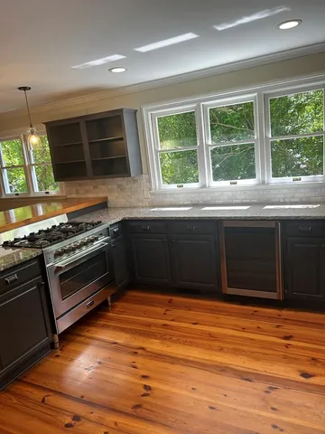 a kitchen with stainless steel appliances granite countertop a stove and a sink
