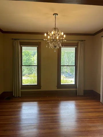 a view of a room with wooden floors and chandelier