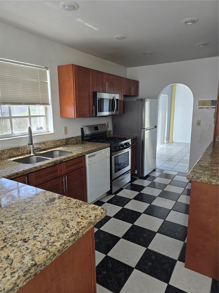 12687 Southwest 146th Street Miami, FL 33186 - Photo 16 of 20 a kitchen with stainless steel appliances granite countertop a sink stove and refrigerator