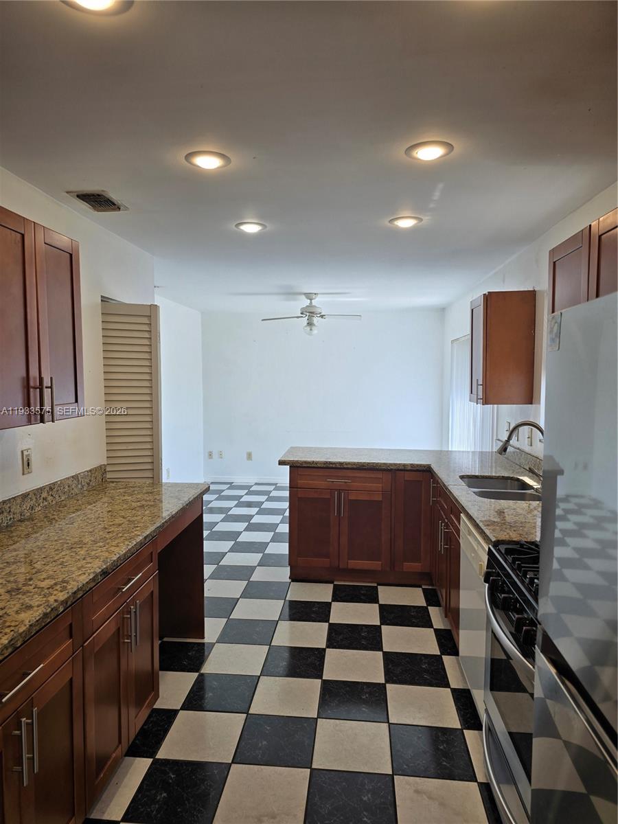 12687 Southwest 146th Street Miami, FL 33186 - Photo 17 of 20 a kitchen with a sink a stove and cabinets