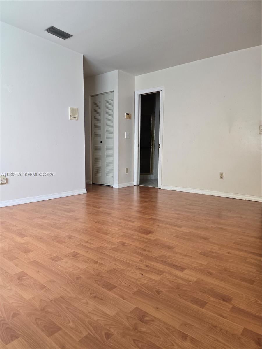 12687 Southwest 146th Street Miami, FL 33186 - Photo 6 of 20 a view of an empty room with wooden floor and a window