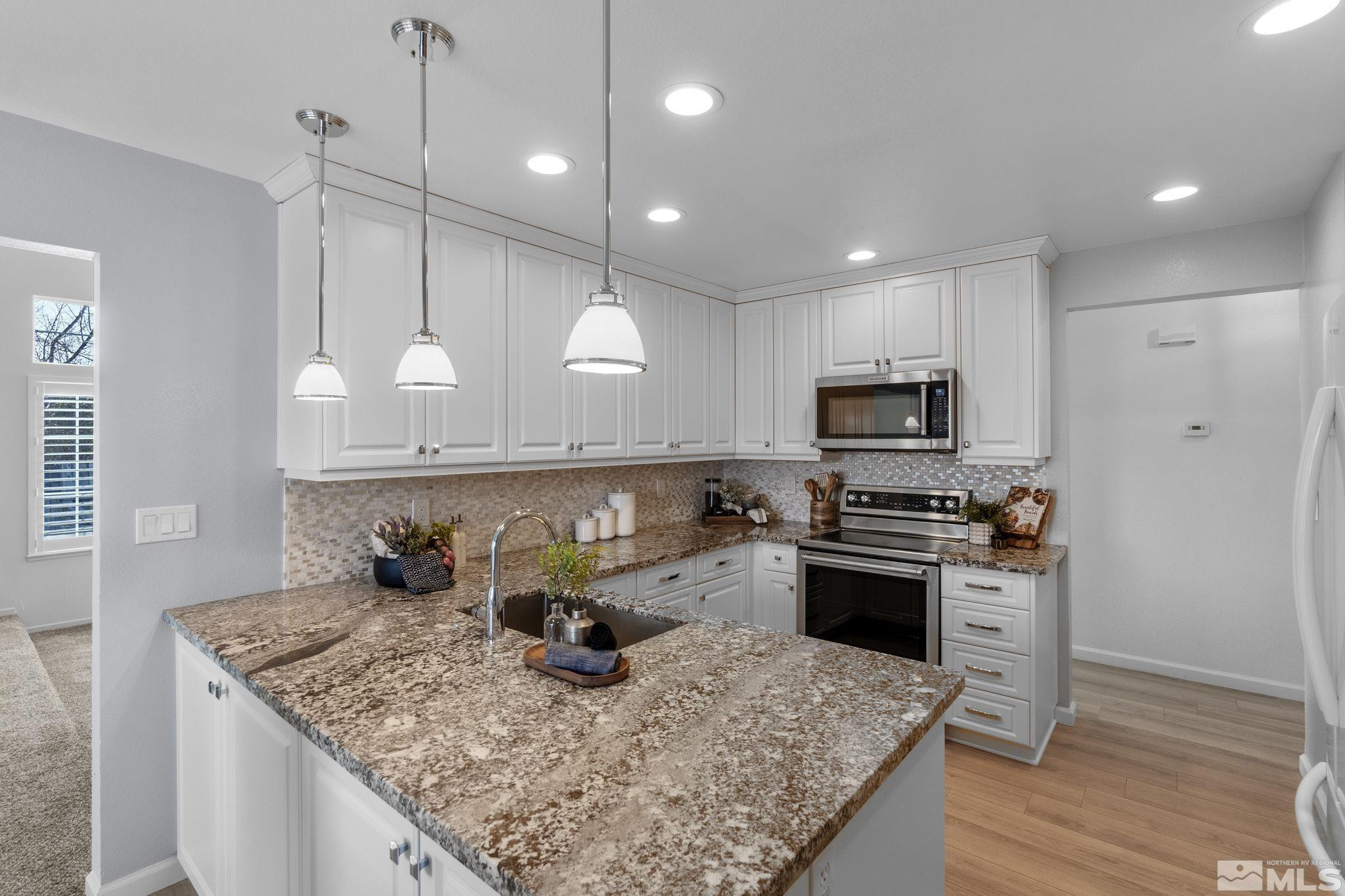 2332 Madera Court Reno, NV 89523 - Photo 14 of 36 a kitchen with stainless steel appliances granite countertop a sink a stove and a wooden floors