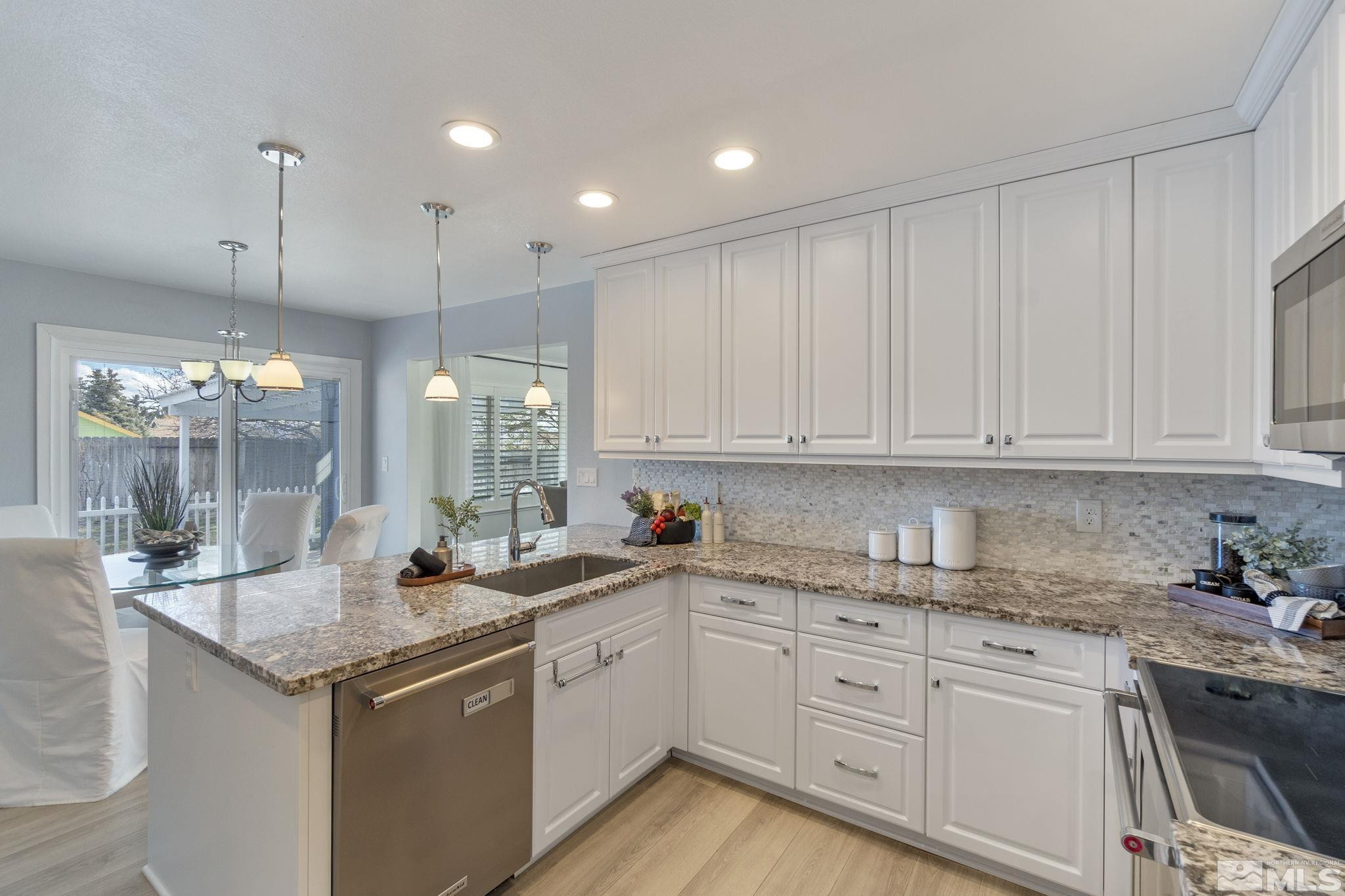2332 Madera Court Reno, NV 89523 - Photo 18 of 36 a kitchen with granite countertop white cabinets and white appliances