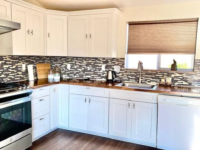 a kitchen with granite countertop white cabinets and white appliances