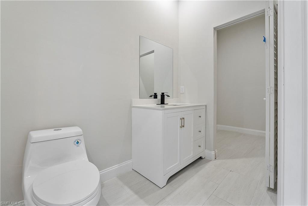 3702 66th Avenue Northeast Naples, FL 34120 - Photo 6 of 10 Bathroom with vanity, baseboards, and toilet