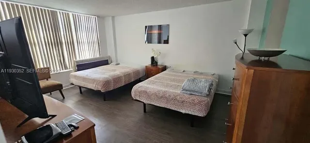 a bedroom with two beds and wooden floor