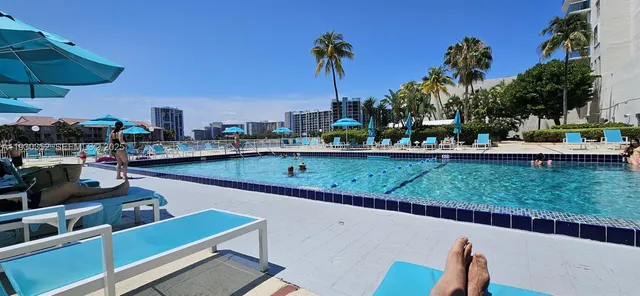 a view of a chairs and table in patio with a swimming pool