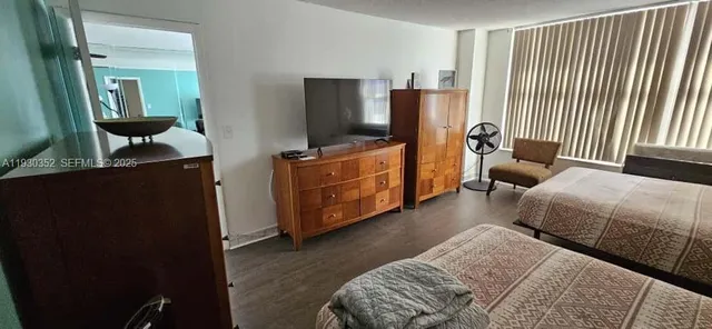 a bedroom with furniture and a flat screen tv