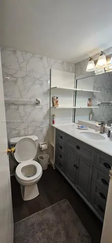 a bathroom with a sink a toilet and a mirror