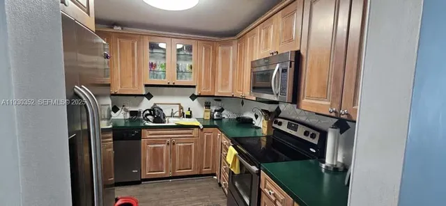 a kitchen with stainless steel appliances granite countertop a stove a sink and a refrigerator